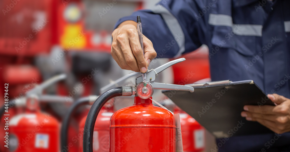 Engineer are checking and inspection a fire extinguishers tank in the fire control room for safety training and fire prevention.